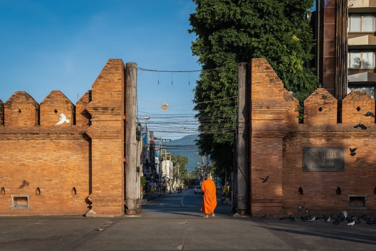 A Buddhist monk walking through the Tha Prae Gate which is an ancient city gate in Chiang Mai, Thailand 