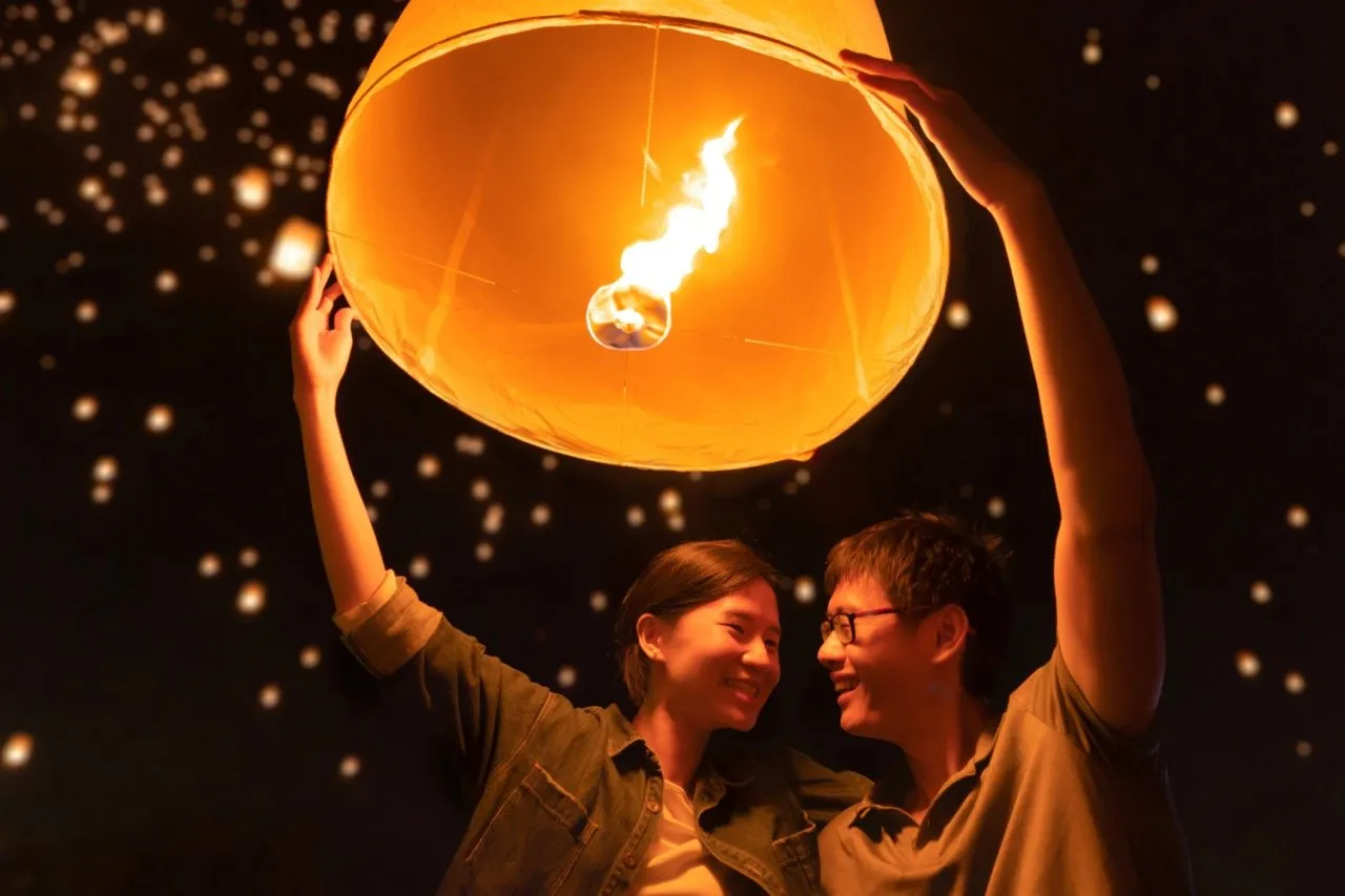 A couple releasing a floating lantern into the sky