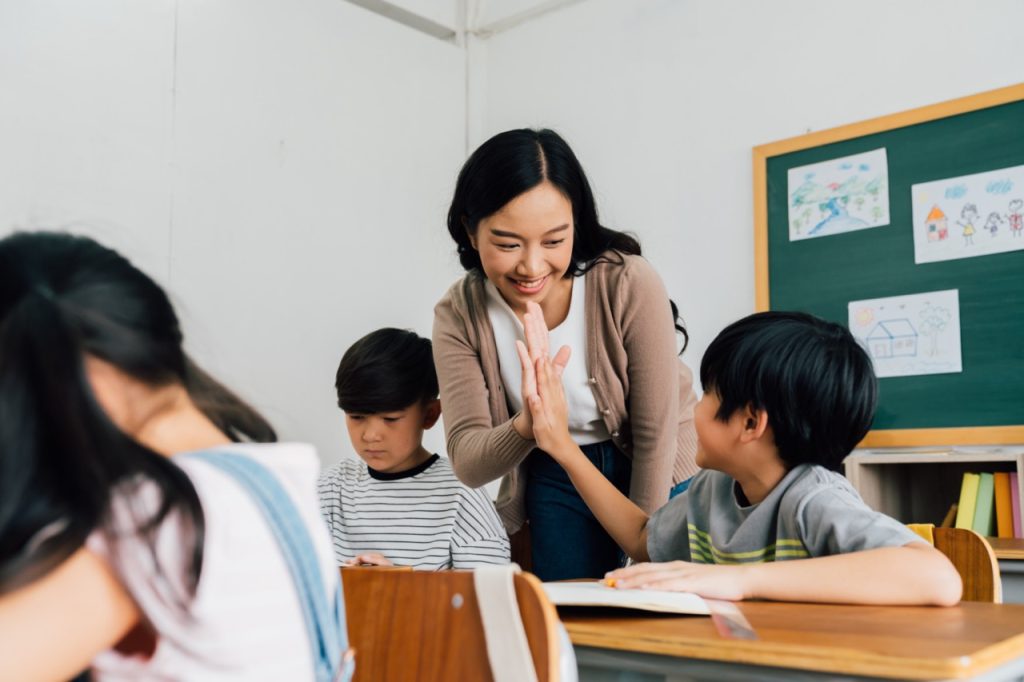 A teacher giving a student a high five