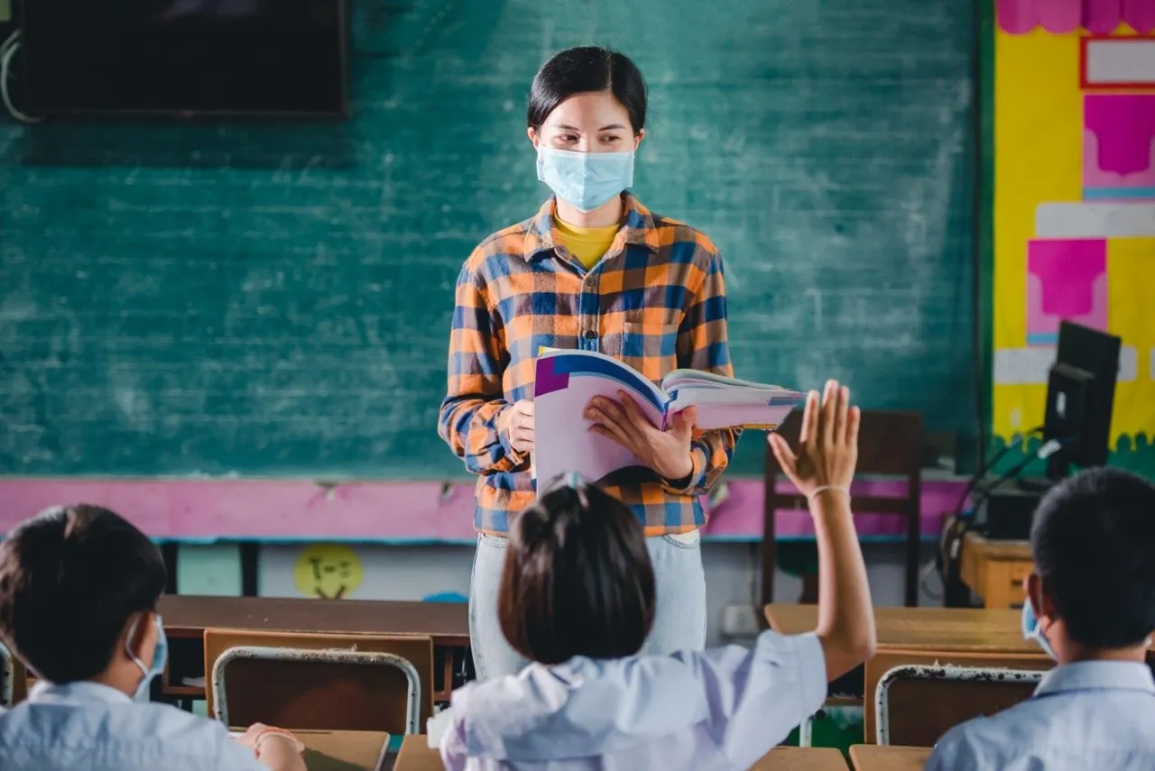A student putting her hand up to ask the teacher questions