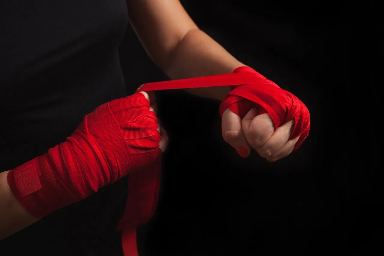A female boxer wrapping her hands with boxing hand wraps