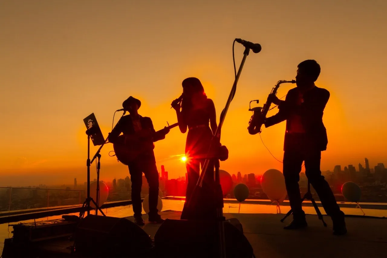 A silhouette of a band playing at a live music event