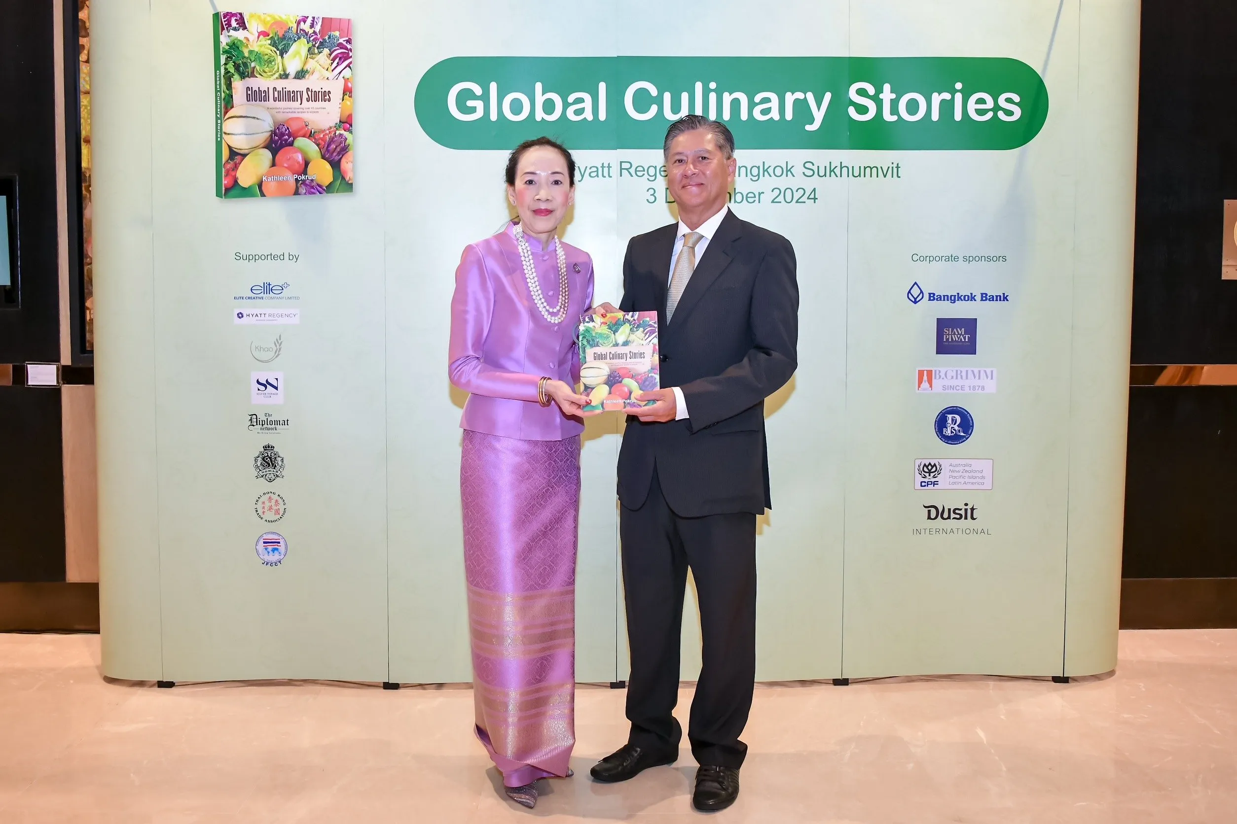 Author Kathleen Pokrud (left) holding a copy of her book, Global Culinary Stories, with Russ Jalichandra, Vice Minister for Foreign Affairs