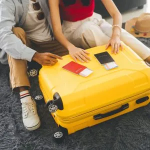 Young adults with passports on a luggage, getting ready for a trip