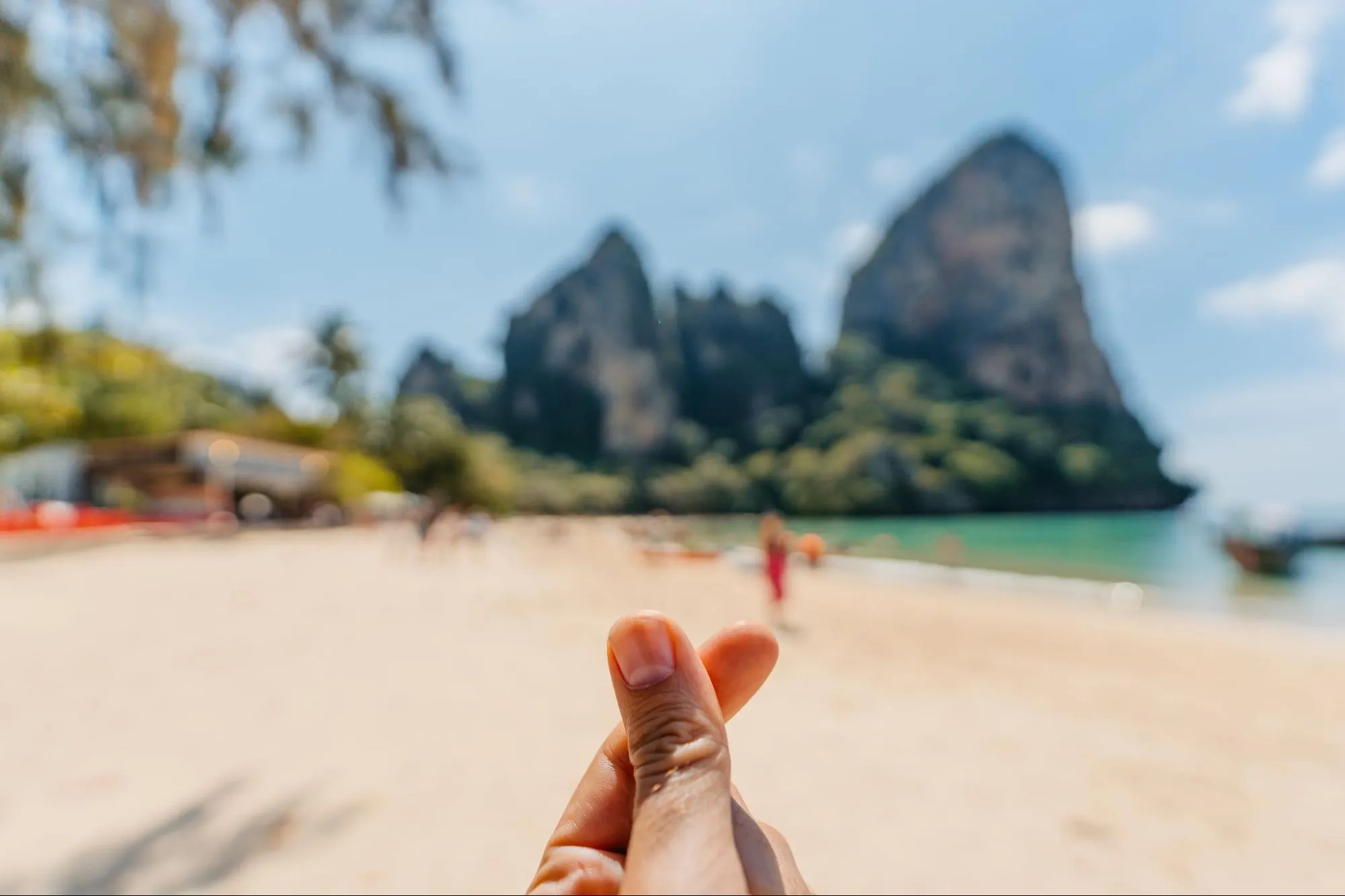 A mini heart hand sign in front of the beach in Thailand