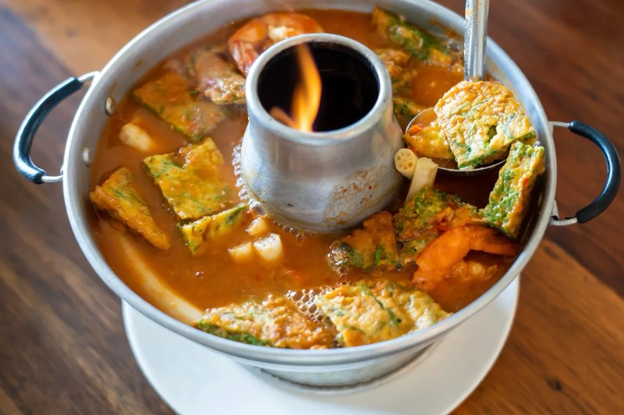 Spicy tamarind soup with shrimp, omelette, and red curry or Kaeng Som