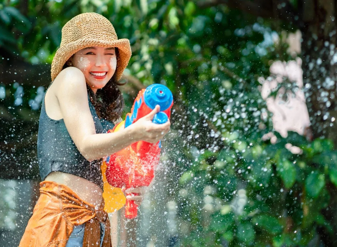 An Asian girl using a water gun