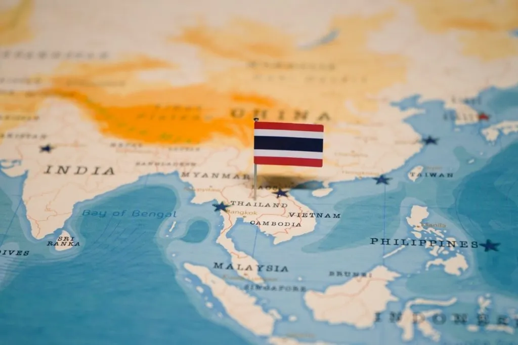Map of Thailand with a Thai flag pinned over Thailand
