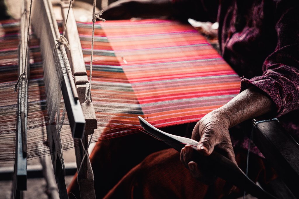 A traditional weaver making Thai silk at a loom.