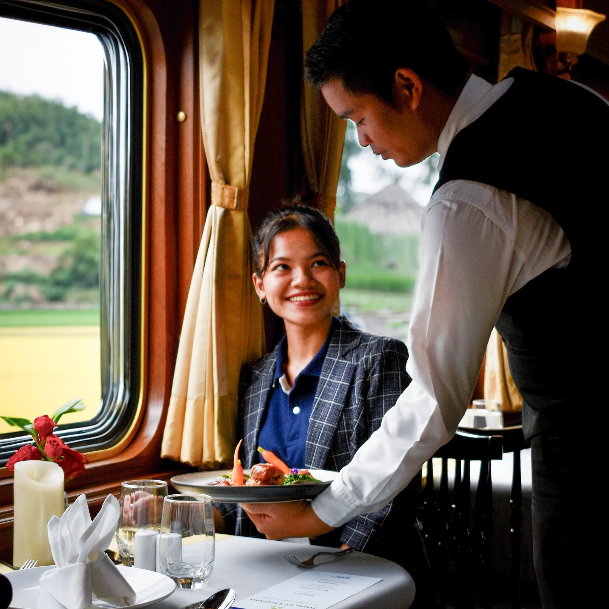 A waiter serving gourmet meals on the Blue Jasmine Train