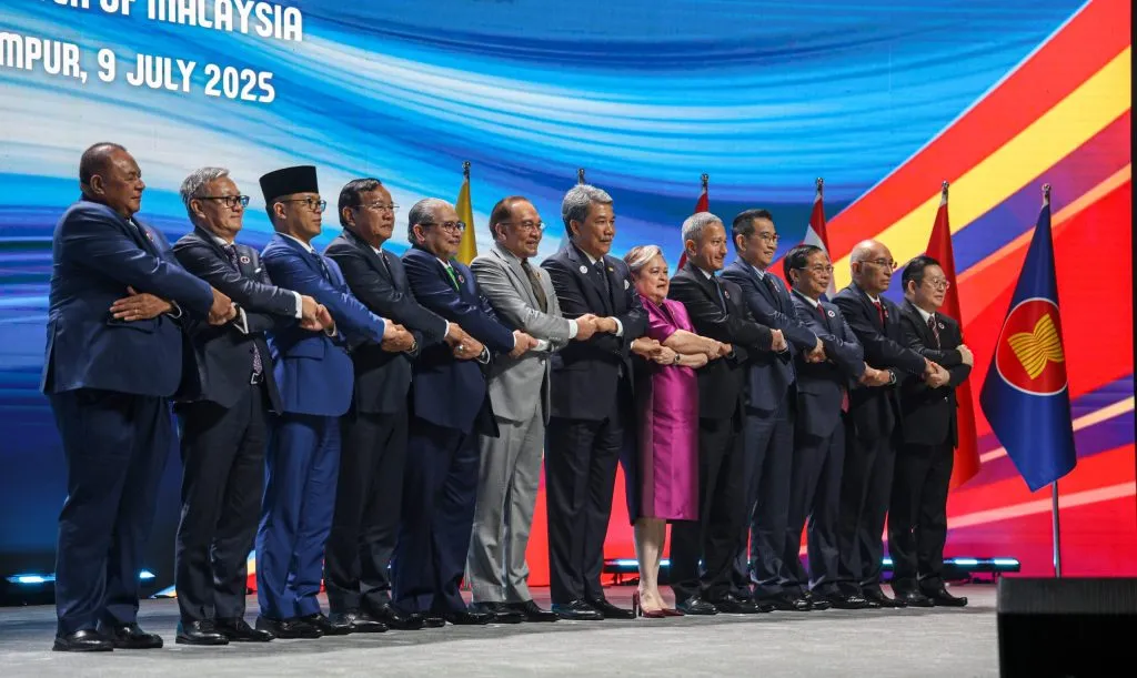 Foreign ministers of ASEAN member states interlocking hands at the 58th ASEAN Foreign Ministers’ Meeting held in Kuala Lumpur.