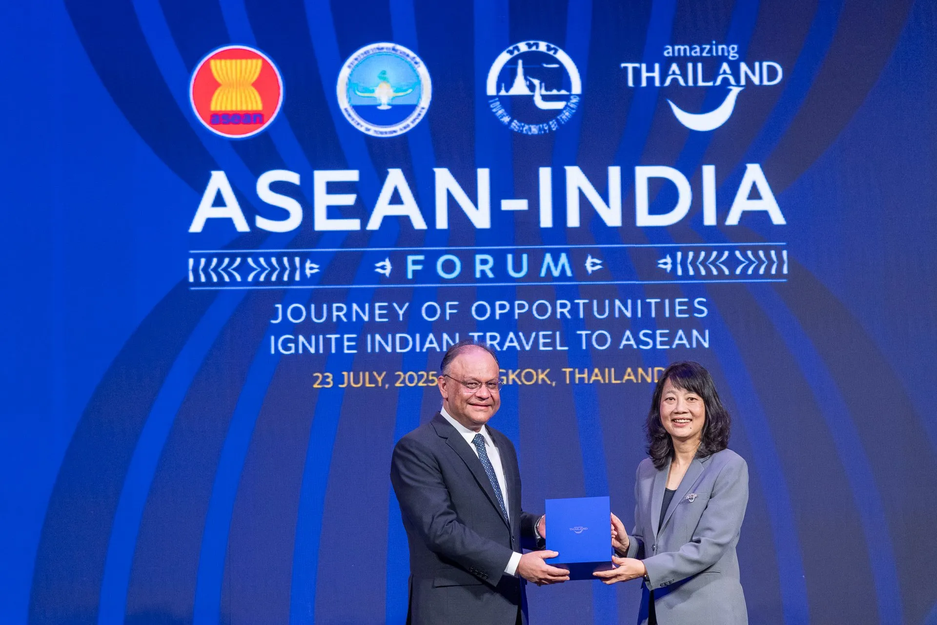Ambassador of India to Thailand Nagesh Singh holding a commemorative plaque with TAT Deputy Governor Pattaraanong Na Chiangmai.