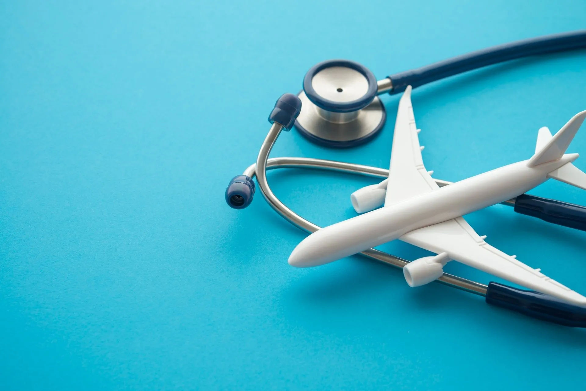 Airplane and stethoscope on a blue background