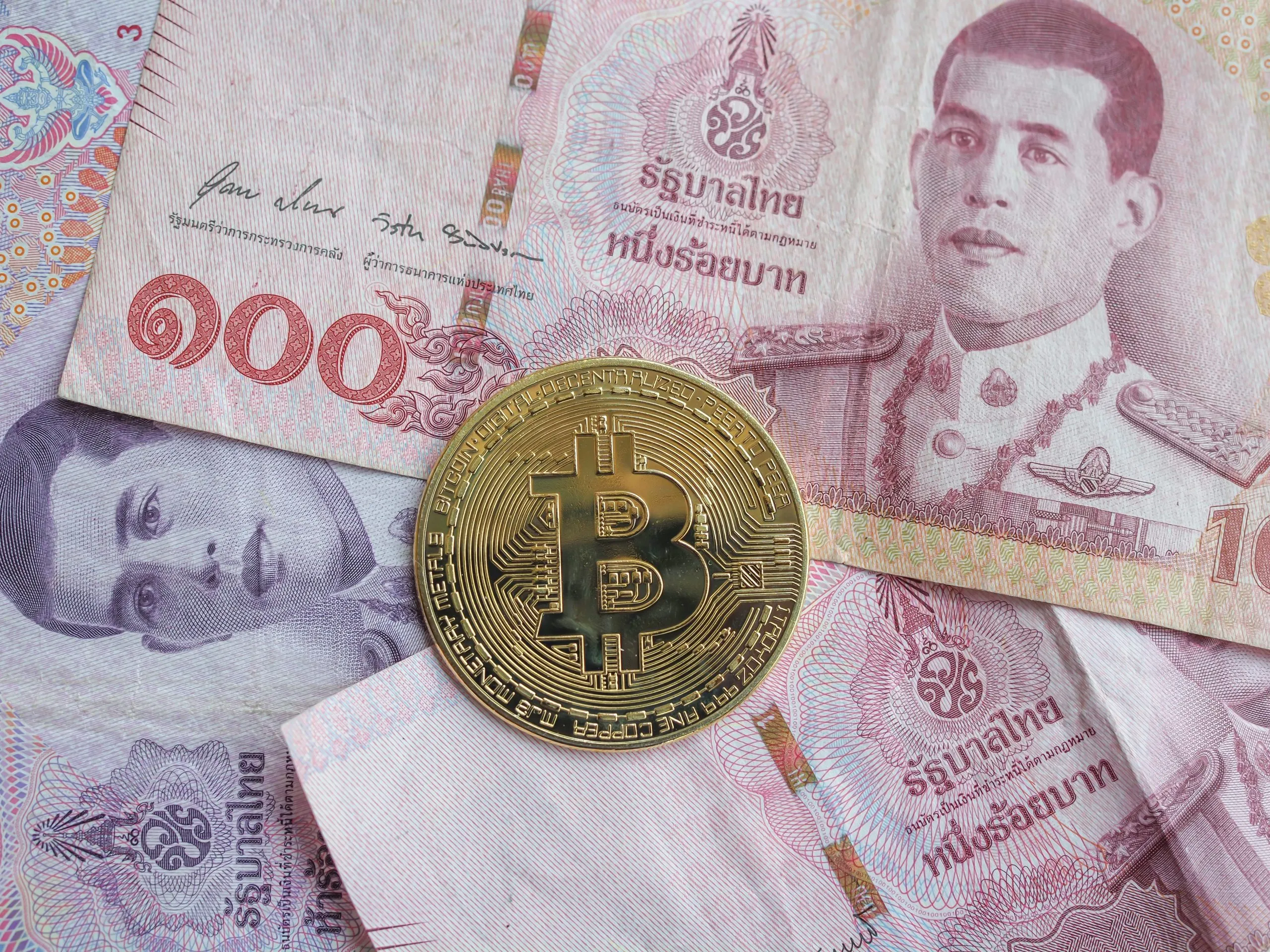 BTC crypto coins on banknotes, Thai baht currency