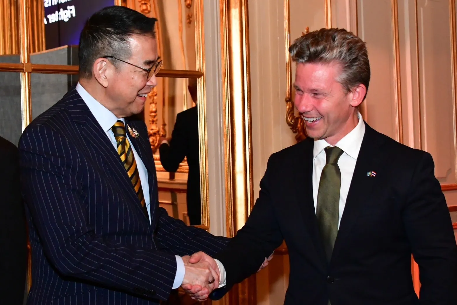 Thailand’s Minister of Foreign Affairs Maris Sangiampongsa shakes hands with Sweden’s Defense Minister Pal Jonson