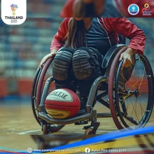 a female athlete on a wheelchair wearing protective gear. a volleyball is resting on her feet.