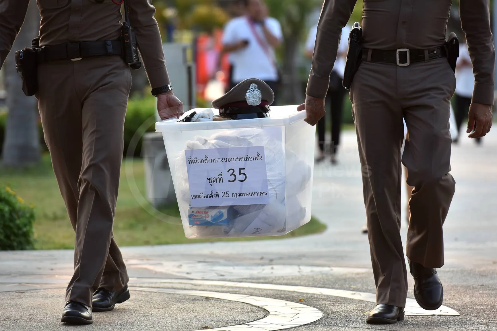 two police officers carrying a ballot box