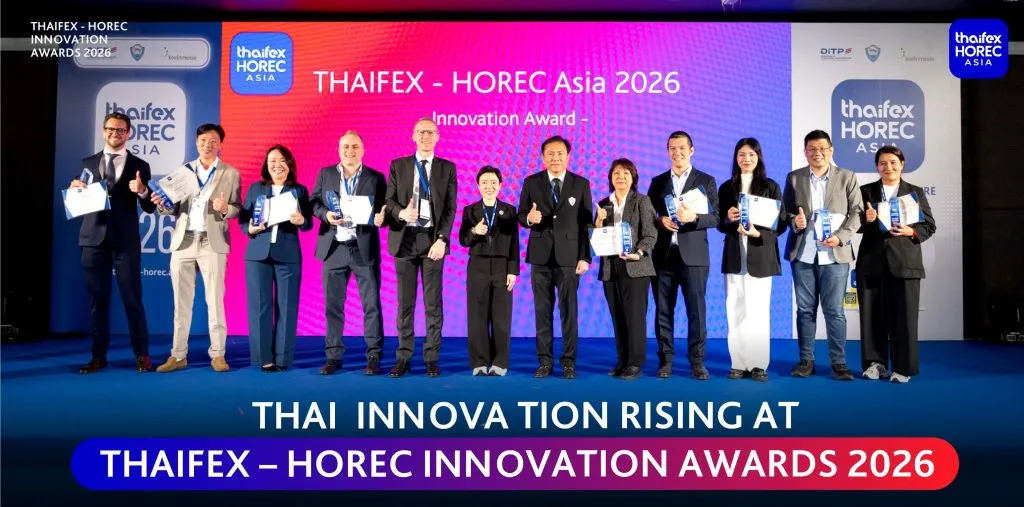 Thirteen winners in business attire smile and give thumbs-up on a bright blue stage before a vibrant pink-purple backdrop at THAIFEX Innovation Awards 2026. 