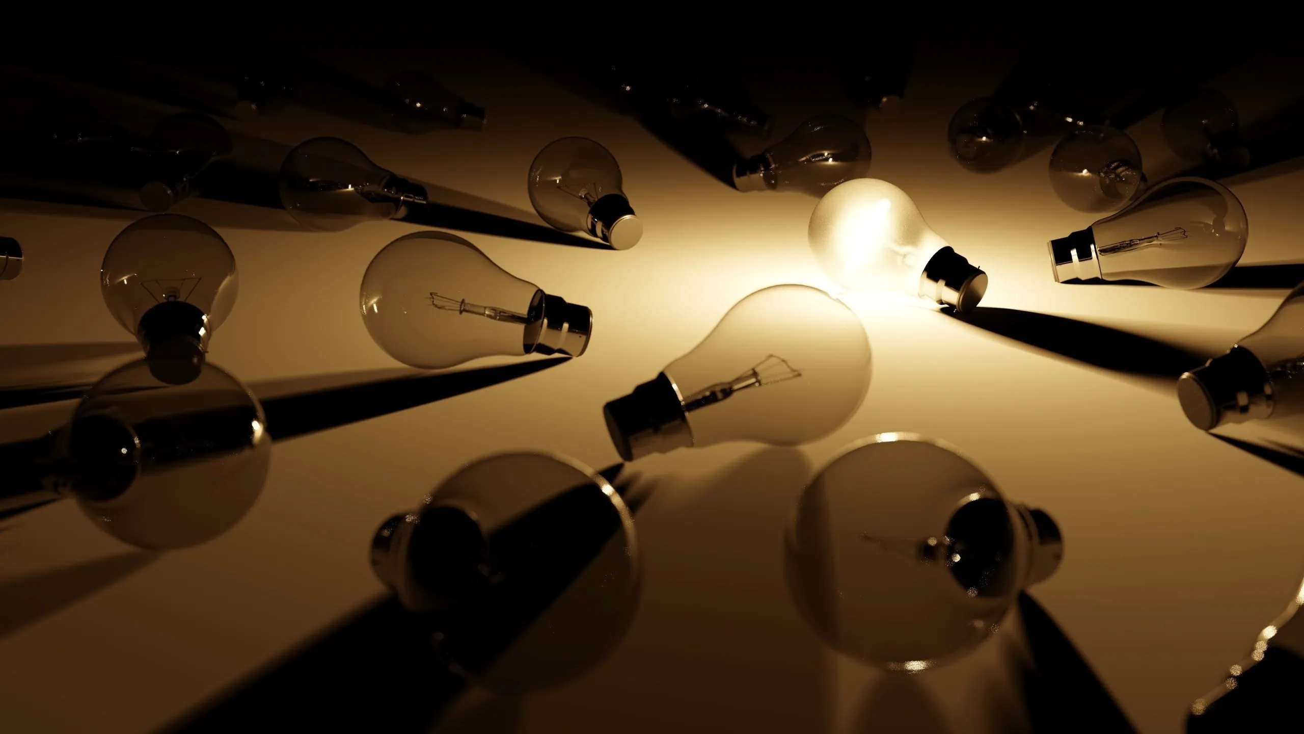Several light bulbs placed on a platform only one emits light, illuminating an otherwise dark area.