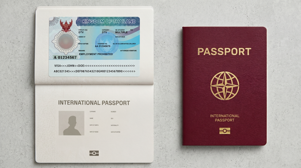 An open passport displays a blue Thai visa sticker marked "EMPLOYMENT PROHIBITED," resting beside a closed, dark red international passport on a gray surface.