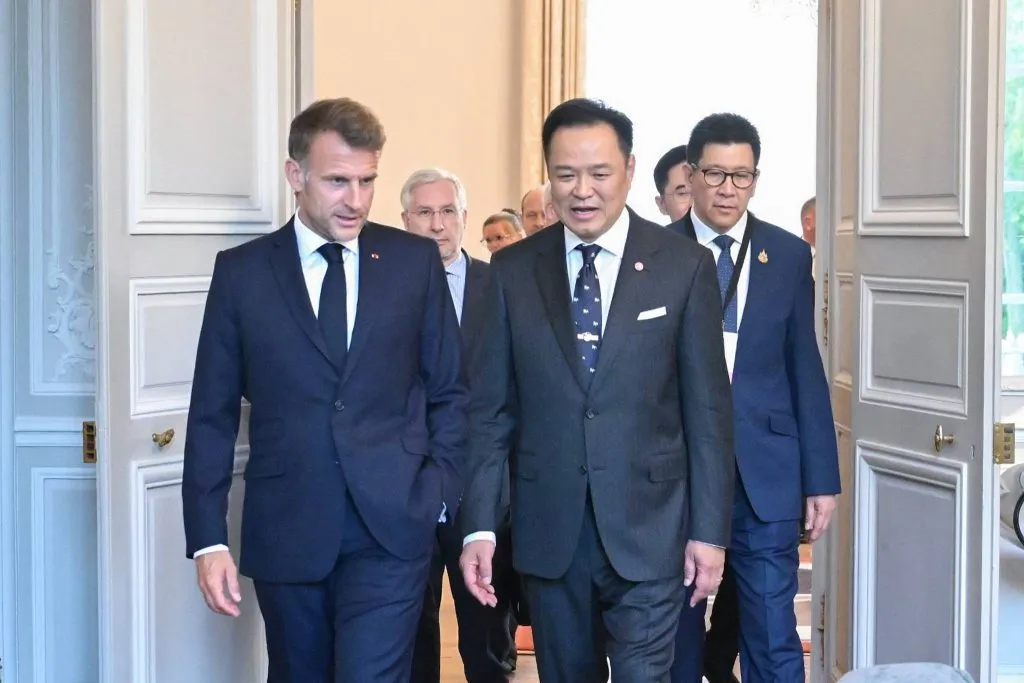 Officials walk side-by-side through an elegant indoor doorway.