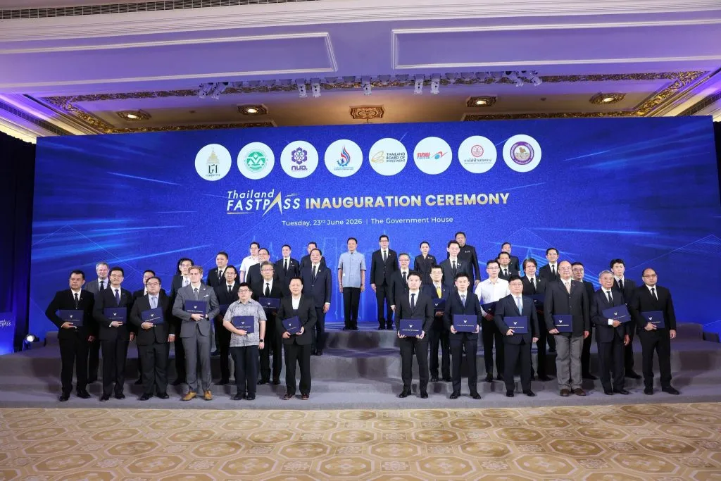A large group of officials stands on a tiered stage for a group photo at an inauguration ceremony.