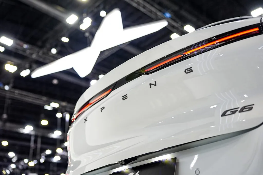 A close-up perspective highlights the rear taillight design and branding of a white XPeng G6 electric car.