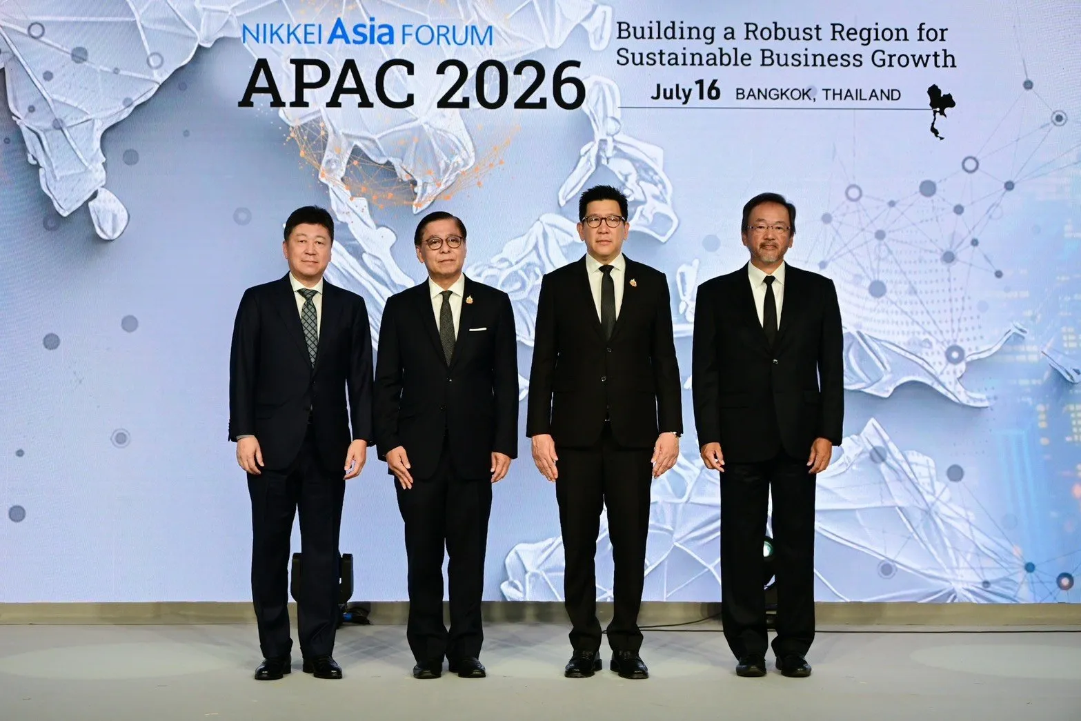 H.E. Mr. Sihasak Phuangketkeow stands alongside other dignitaries on a stage for a photo.