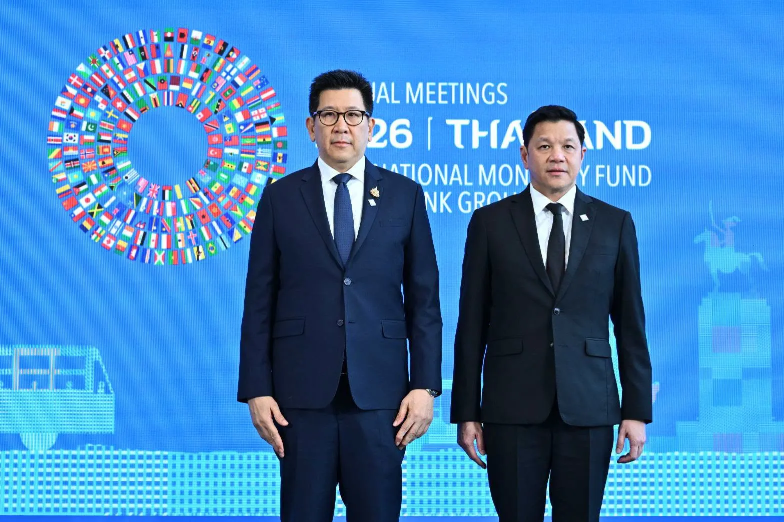 DPM Ekniti Nitithanprapas standing on a stage with another man.