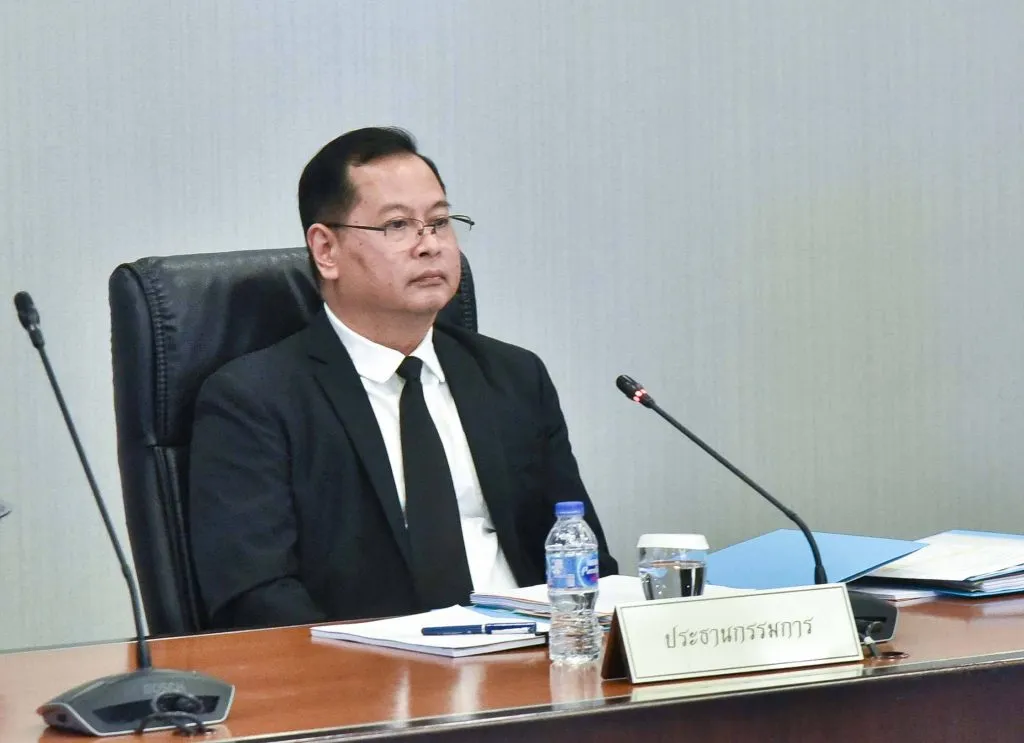Deputy Prime Minister Pakorn Nilprapunt sitting on an office chair in a conference room.
