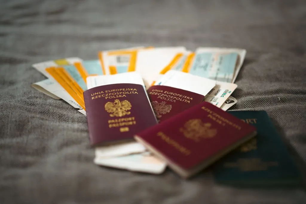3 passports placing on the table with boarding passes between them.
