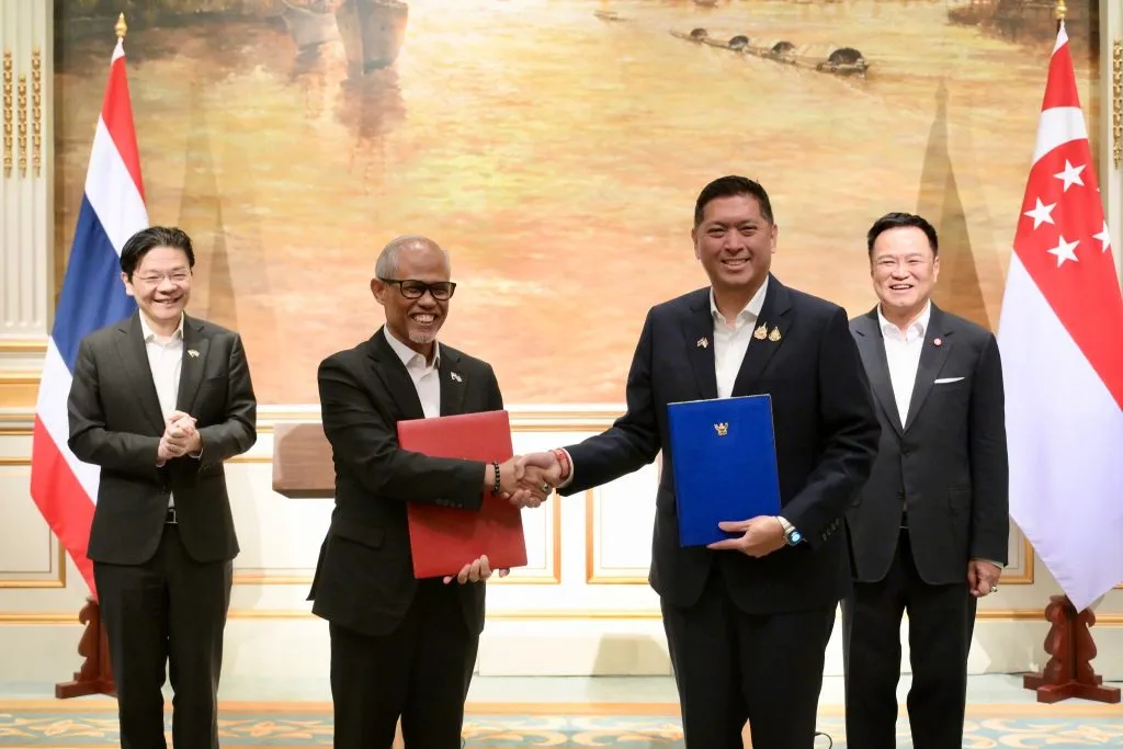 Thai and Singapore officials exchange a memorandum of understanding during the leaders’ retreat in Bangkok.